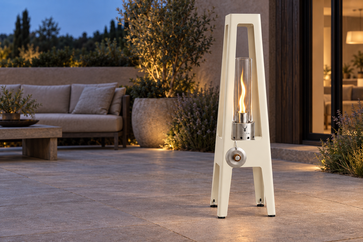 Lampe au bioéthanol TORRE Ivory Frost avec une flamme sur une terrasse en soirée.